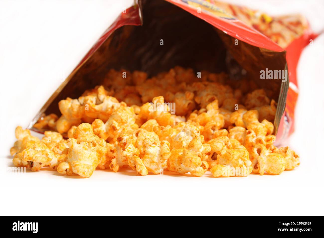 Offene Tüte mit gewürztem Popcorn isoliert auf weißem Hintergrund Stockfoto