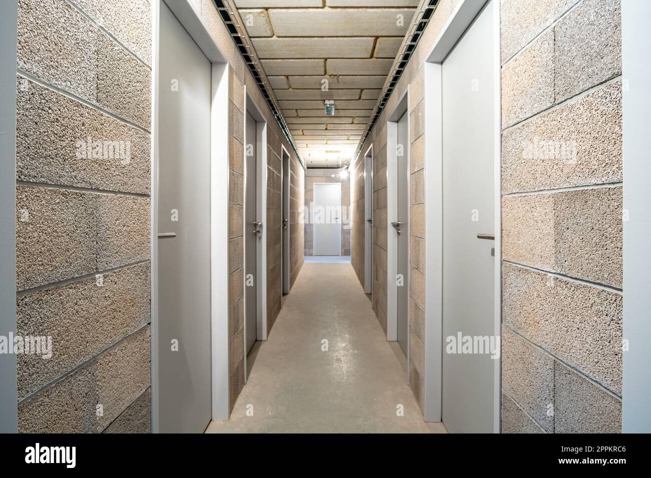 Untergeschossfläche in einem neuen Apartmentgebäude. Korridor mit einer Tür Stockfoto