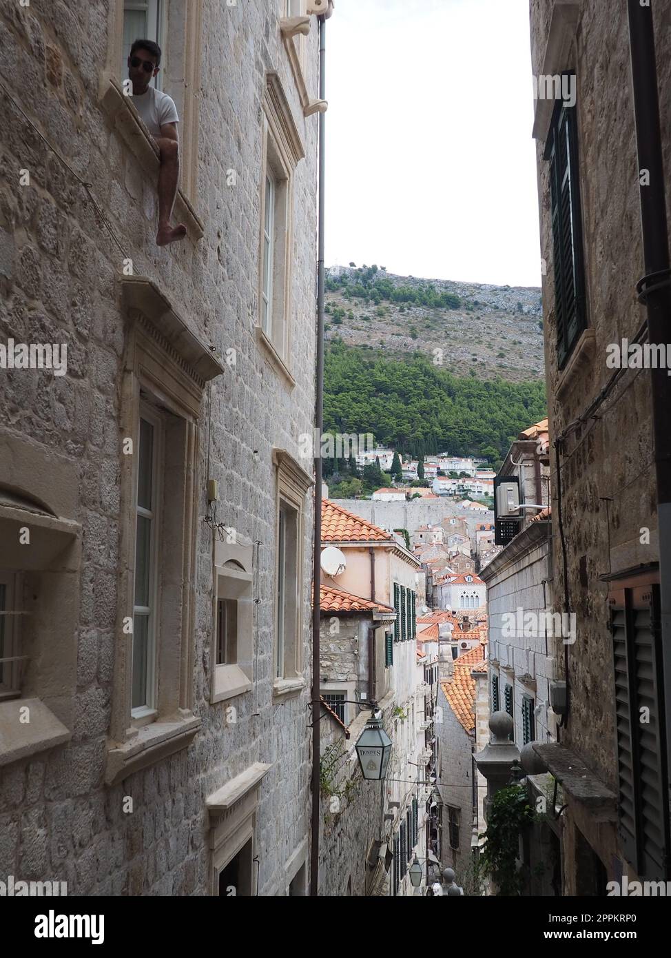 Dubrovnik, Kroatien, 08,14. 2022. Enge Gassen der antiken Stadt. Die Fassaden der Häuser sind aus Marmor und Stein sehr nahe beieinander. Fenster mit Fensterläden. Sommertourismus in der Adria. Stockfoto