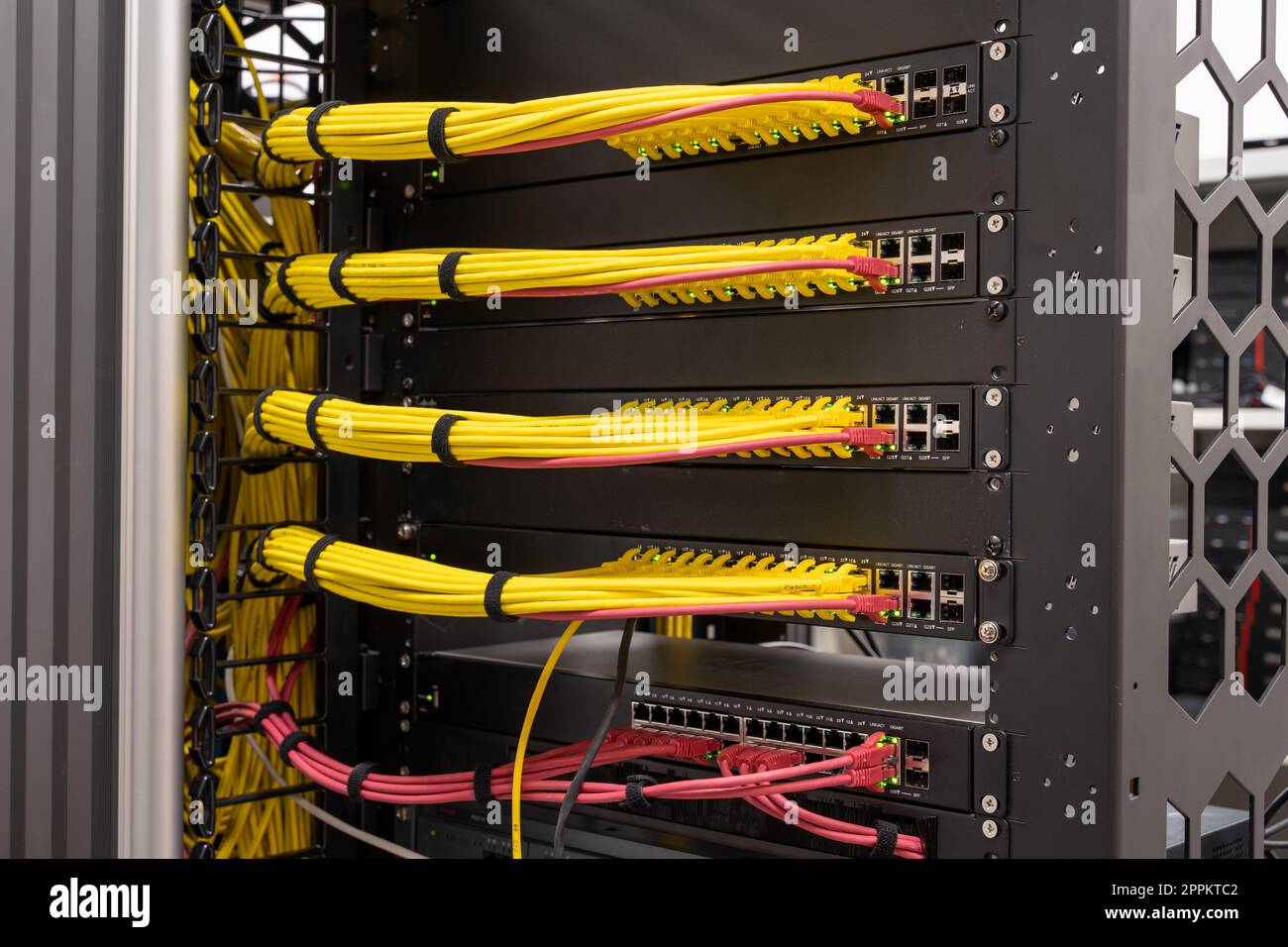 Ordentliche, gepatchte Netzwerkkabel, RJ45, angeschlossen an Switches und Router, Rechenzentrum Stockfoto