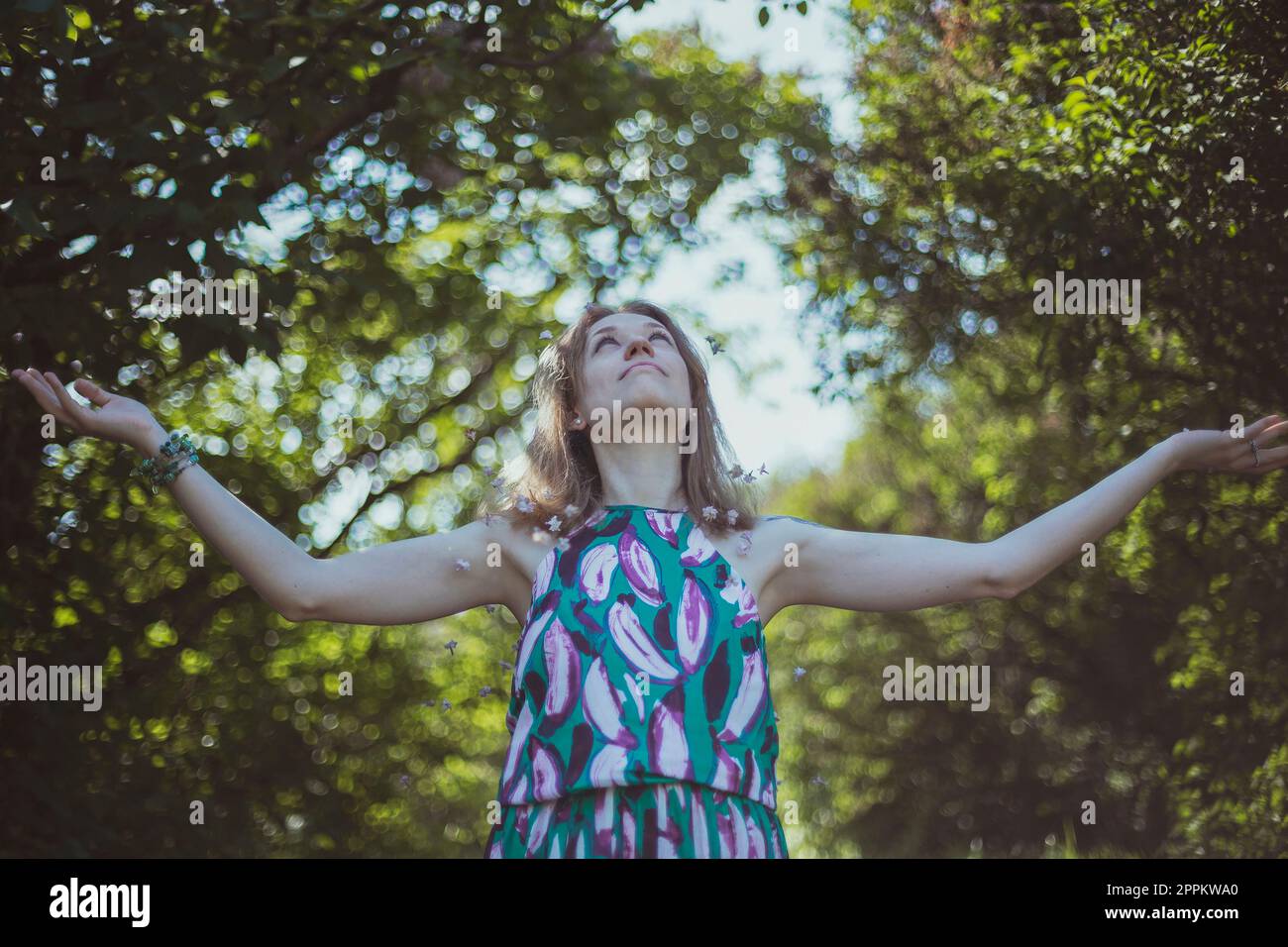 Glückliches Mädchen im Sommerkleid, das seine Arme ausbreitet, malerische Fotografie Stockfoto