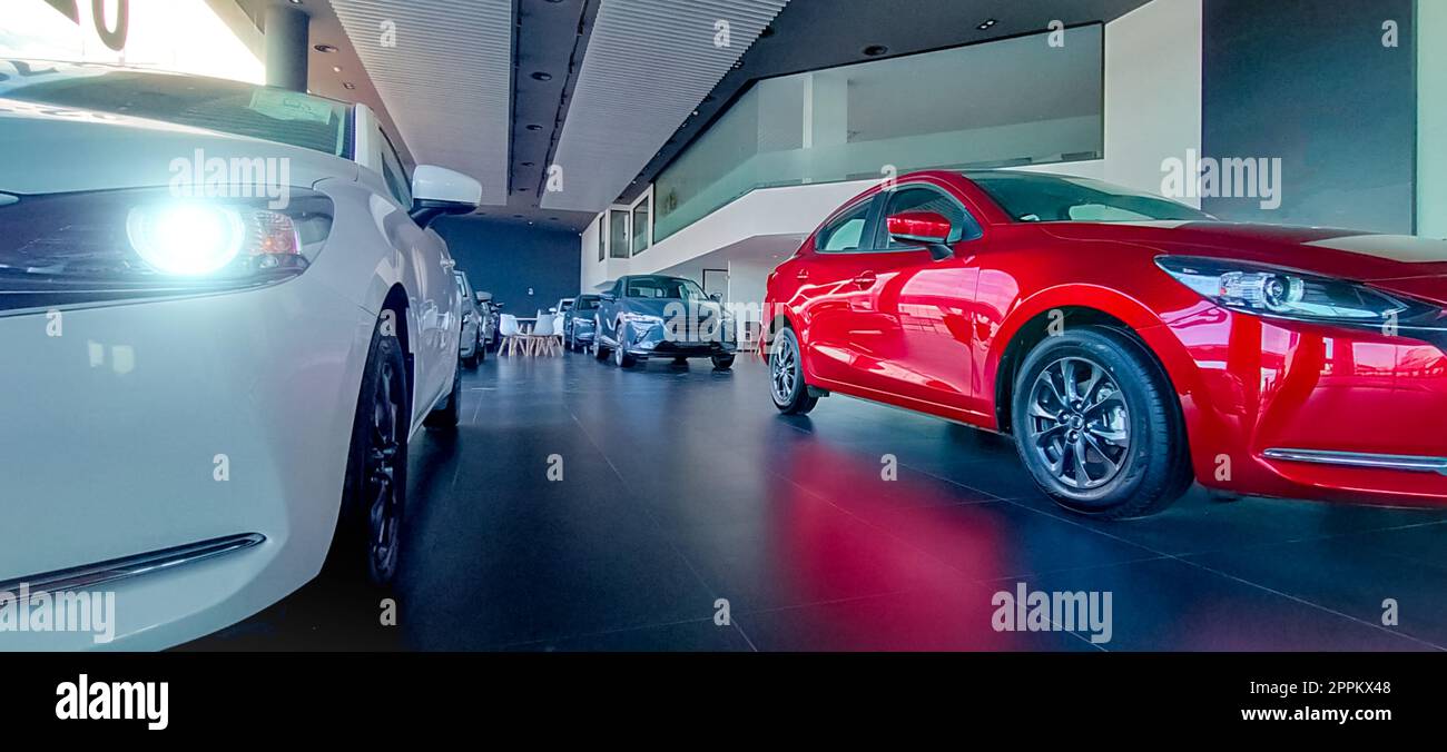 Auto parkt in einem luxuriösen Ausstellungsraum. Büro des Autohändlers. Neues rotes Auto im modernen Ausstellungsraum. Geschäftskonzept Auto zum Verkauf und zur Miete. Kfz-Leasing- und Versicherungskonzept. Autohändler. Stockfoto