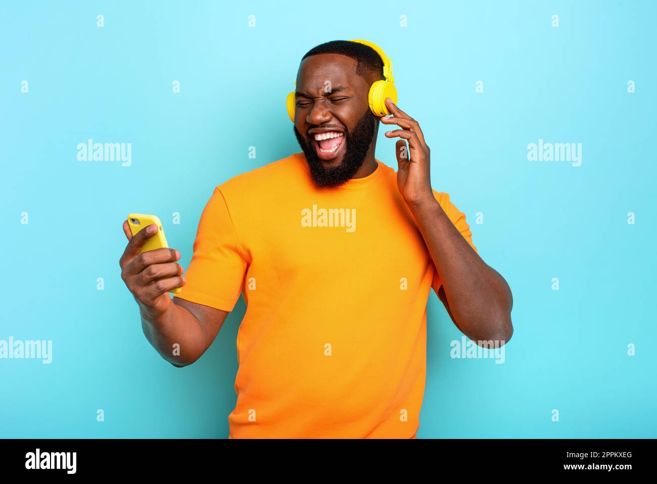 Junge mit gelb Headset hört Musik und Tänze. emotionalen und energetischen Ausdruck Stockfoto