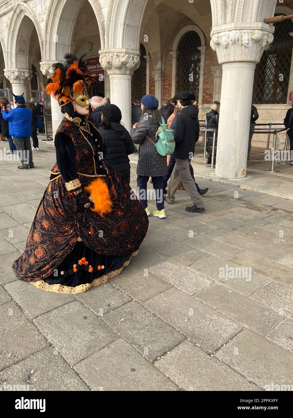 Frau in Kleidung und Touristen auf der Piazza San Marco Stockfoto