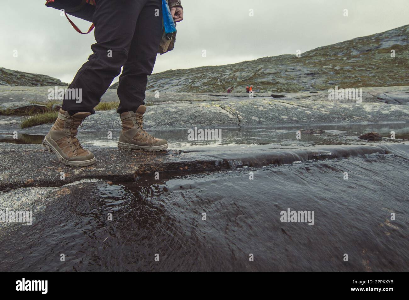 Reisende, die den Bergfluss überqueren, fotografieren Stockfoto