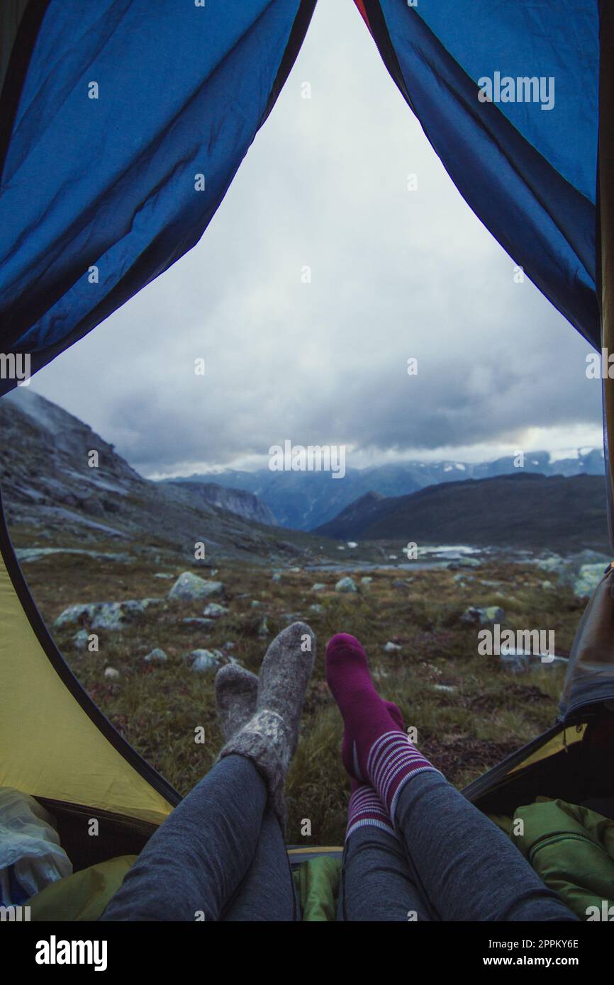 Nahaufnahme der weiblichen Beine mit Socken beim Konzeptfoto des Mountain Camp Stockfoto