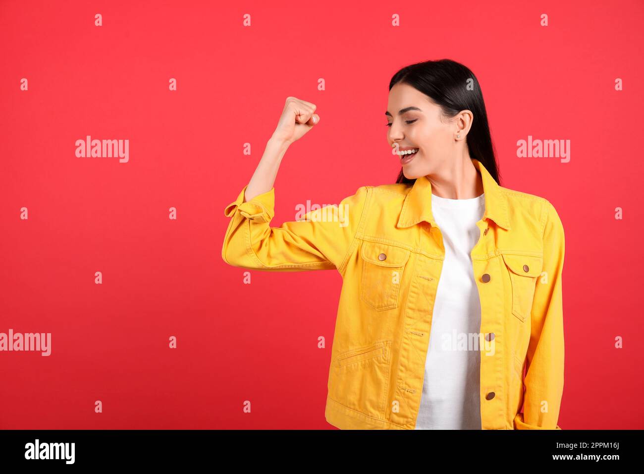 Starke Frau als Symbol der Macht eines Mädchens auf rotem Hintergrund, Platz für Text. Konzept vom 8. März Stockfoto