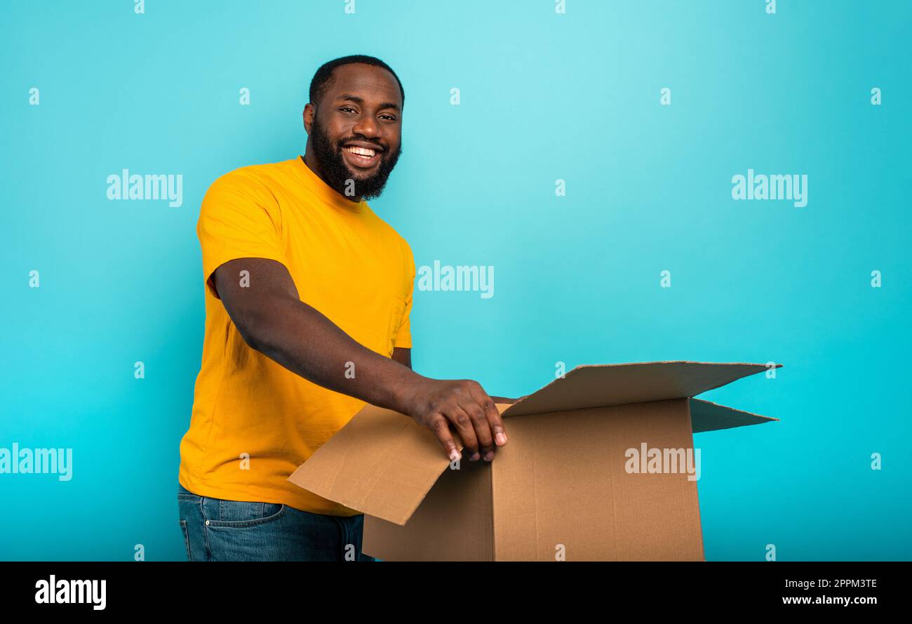 Happy Boy erhält ein Paket aus Online-Shop-Bestellung. Blauer Hintergrund. Stockfoto