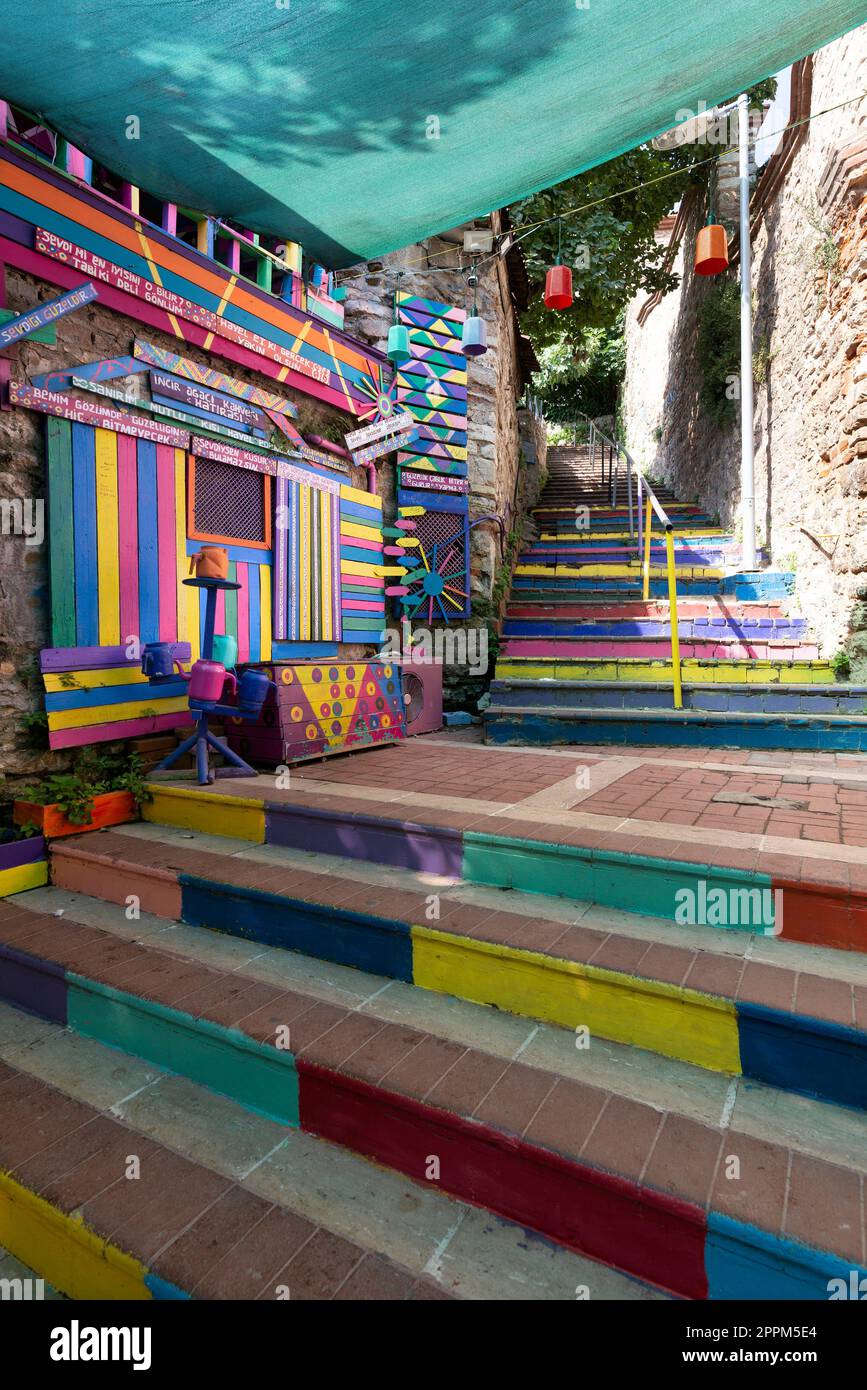 Tagsüber gibt es ein Café aus Stein mit bunten Paneelen, farbenfrohen Treppen und Balat District, Istanbul, Türkei Stockfoto