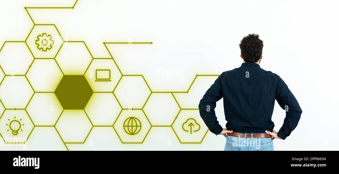 Ein Geschäftsmann in schwarzem Hemd steht mit dem Rücken an der weißen Wand. Futuristisches digitales Design präsentiert neue Technologien der Zukunft. Farbiges Leuchten. Stockfoto