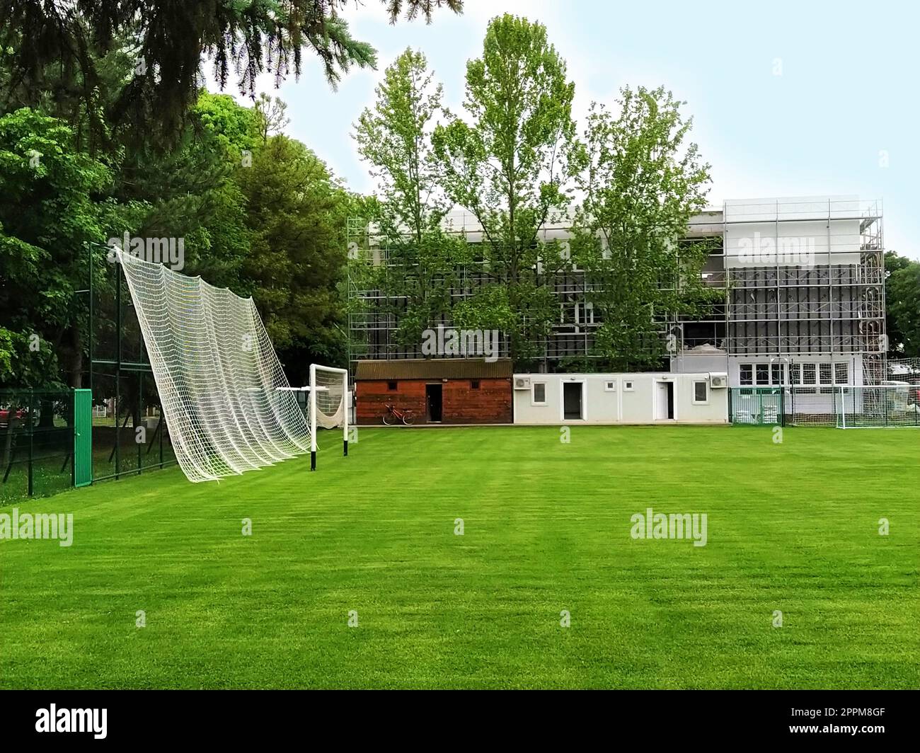 Sremska Mitrovica, Serbien. 30. Mai 2020. Ein Fußballfeld auf dem Schulgelände und ein Fußballtor. Der Bau einer neuen Schule. Schulgebäude in Gerüsten. Fassadenarbeit Stockfoto
