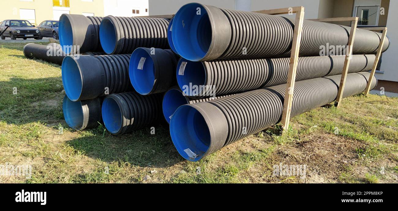 Sremska Mitrovica, Serbien, 23. August 2020. Gewellte Metallrohre, innen blau. Rohre oder Heizungsrohre liegen auf dem Boden neben einem Wohngebäude. Gewelltes Metall Stockfoto