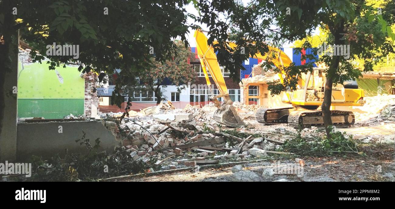 Sremska Mitrovica, Serbien, 13. August 2020. Demontage und Abriss der alten Schule, benannt nach Jovan Popovic. Betonstücke, Bewehrungsstahl hängen. Bulldozer brechen Wände ein. Stockfoto