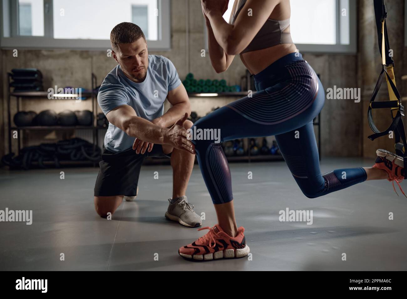 Junge Sportlerin in Sportbekleidung Trainingsbeine mit Aufhängebändern Stockfoto