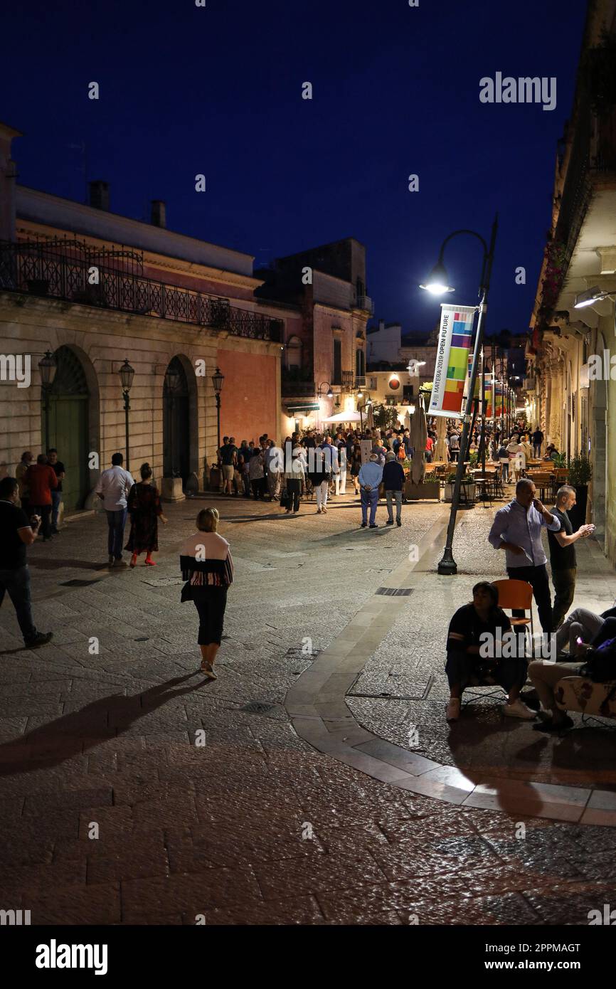 Touristen bei einem Spaziergang auf der kopfsteingepflasterten Straße in der Sassi di Matera, einem historischen Viertel in der Stadt Matera. Stockfoto