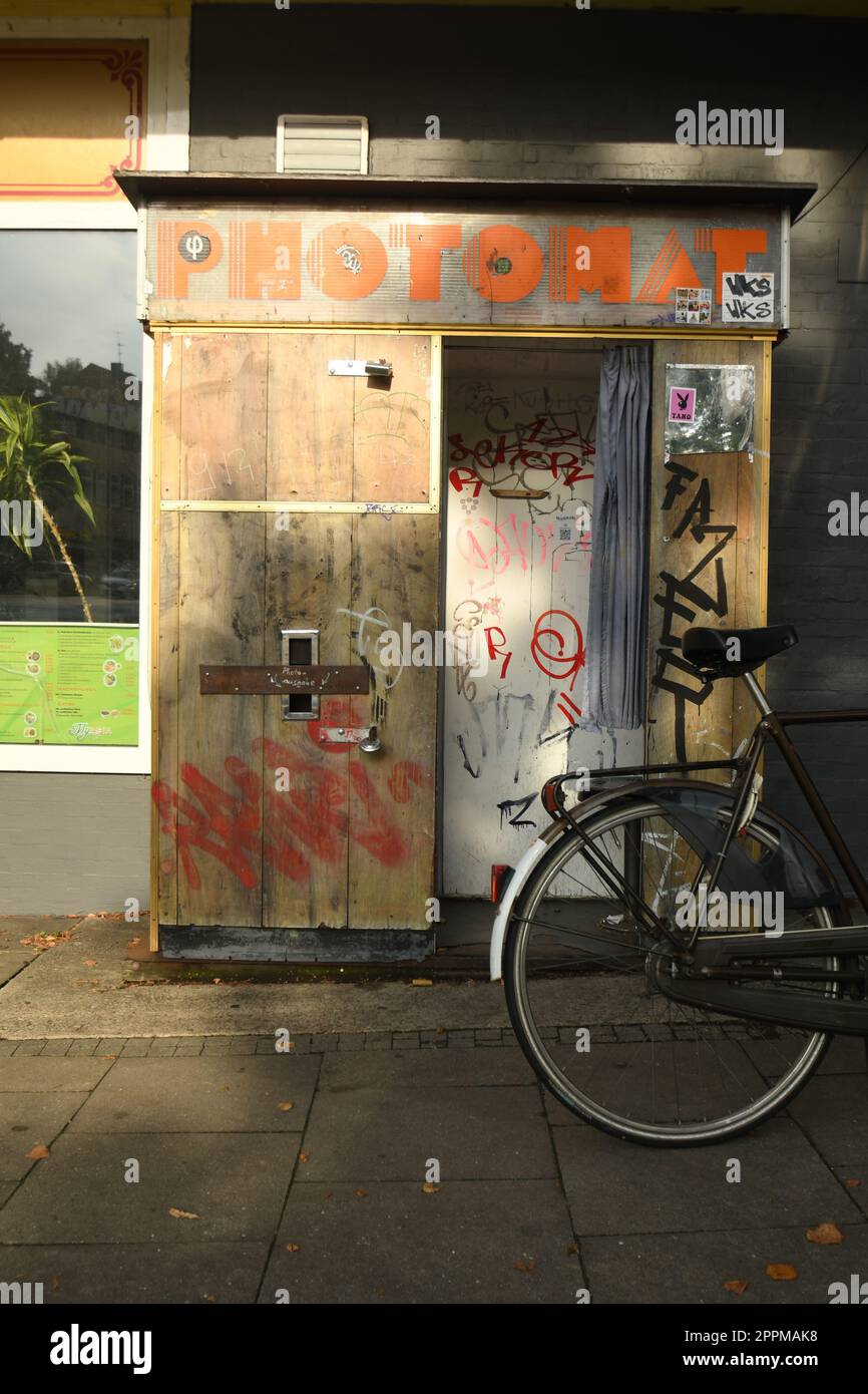 Vertikale Aufnahme eines hölzernen Fotoraums im Vintage-Stil mit einem davor geparkten Fahrrad Stockfoto