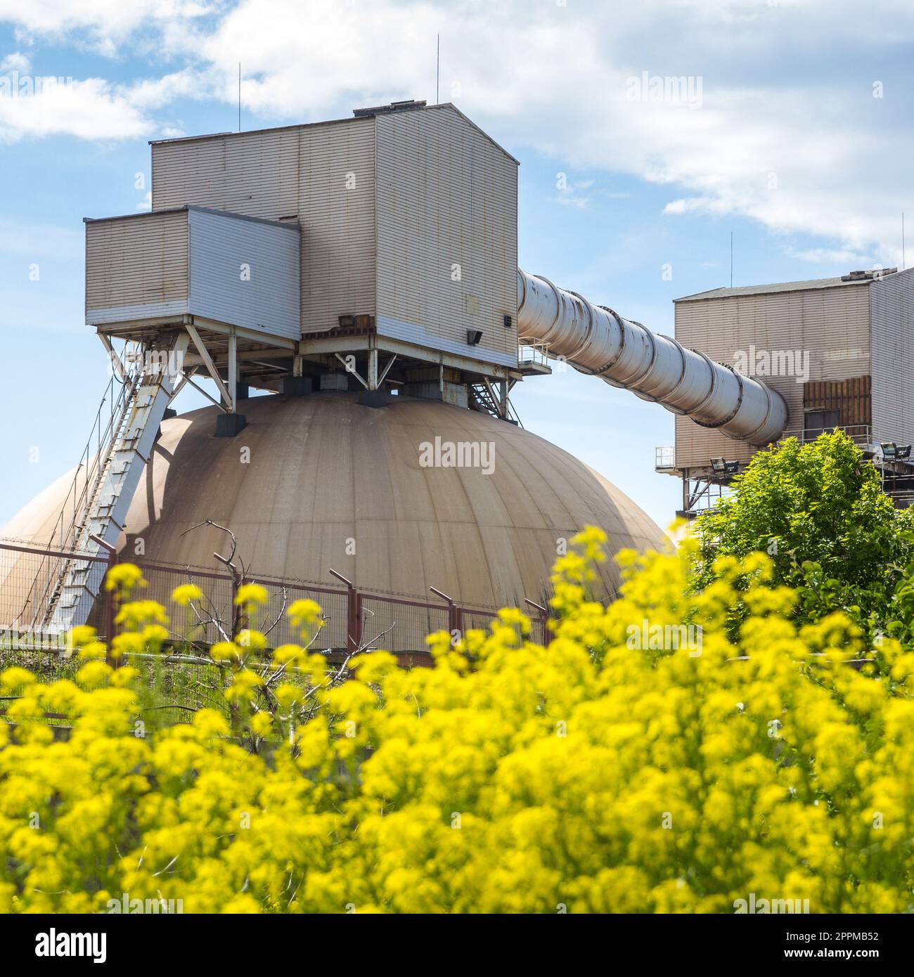 Düngerterminal im Hafen mit gelben Blumen vorne Stockfoto