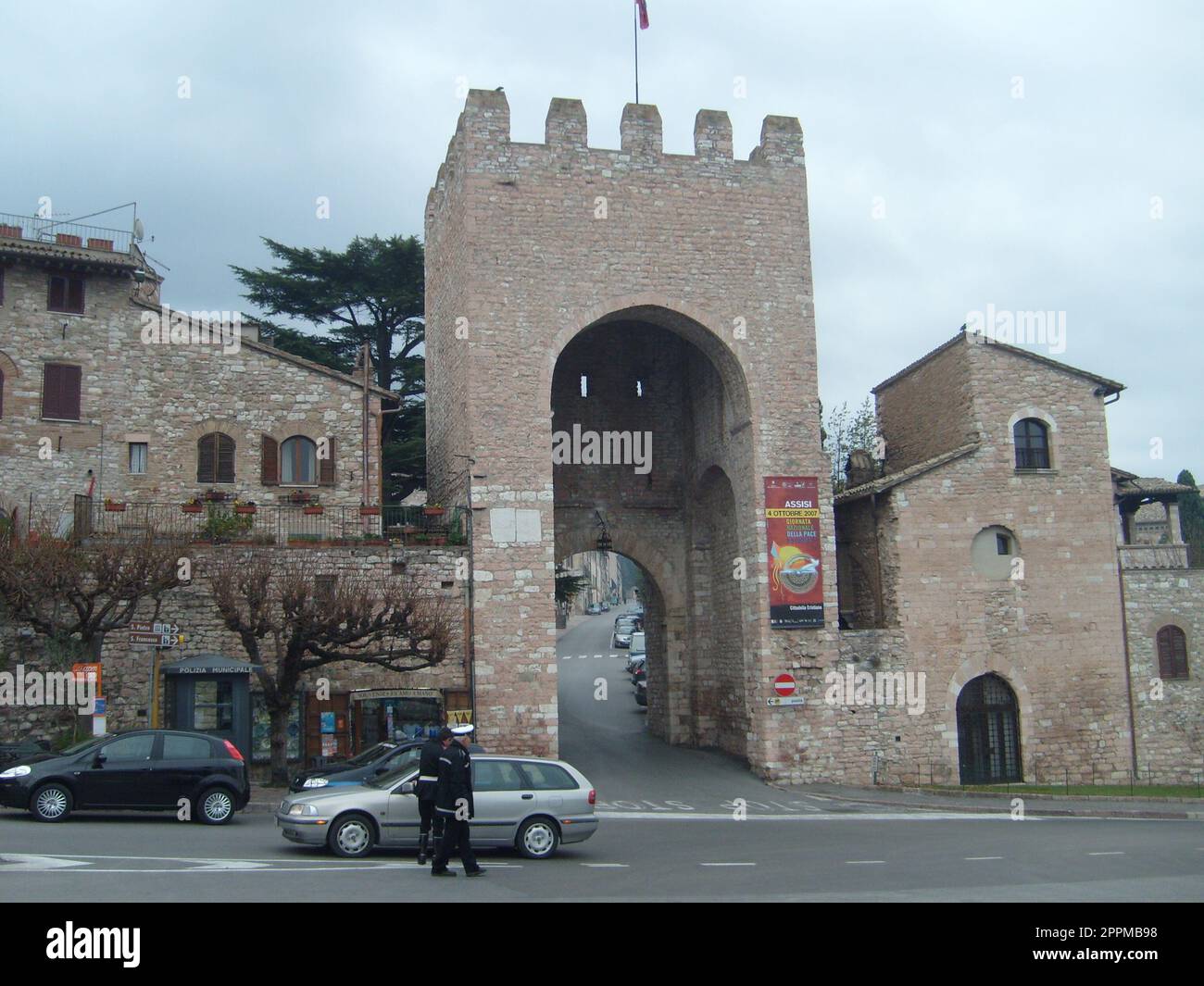 Assisi, Italien, 1. Dezember 2007 Antike Gebäude und Tore in der Stadt Assisi, Umbrien, Italien. Touristenattraktion. Touristen und die italienische Gendarmerie Stockfoto
