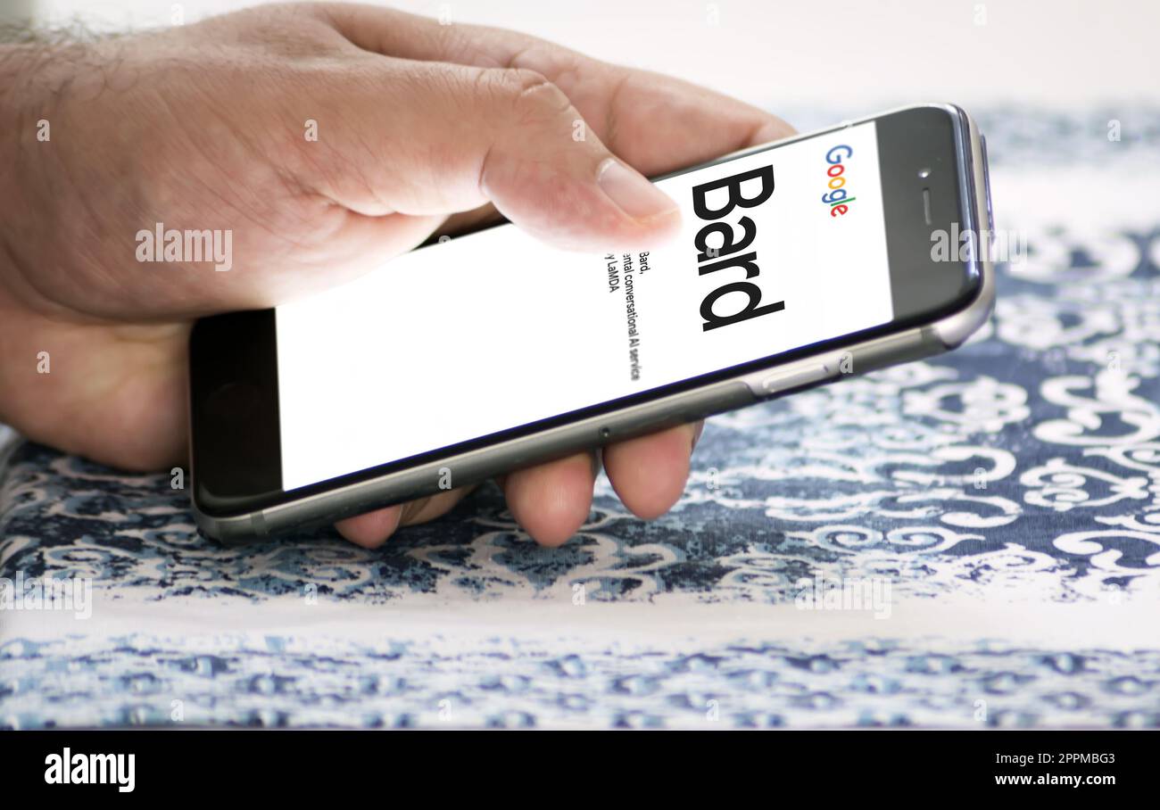 Weibliche Hände halten ein Telefon mit der Google-Bard-Website auf dem Bildschirm Stockfoto