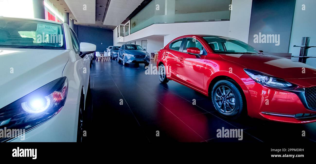 Auto parkt in einem luxuriösen Ausstellungsraum. Büro des Autohändlers. Neues rotes Auto im modernen Ausstellungsraum. Geschäftskonzept Auto zum Verkauf und zur Miete. Kfz-Leasing- und Versicherungskonzept. Autohändler. Stockfoto