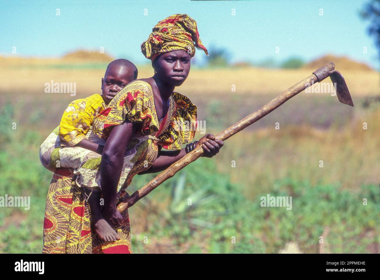 Senegal - Mutter mit Baby jätet auf dem Feld. Stockfoto