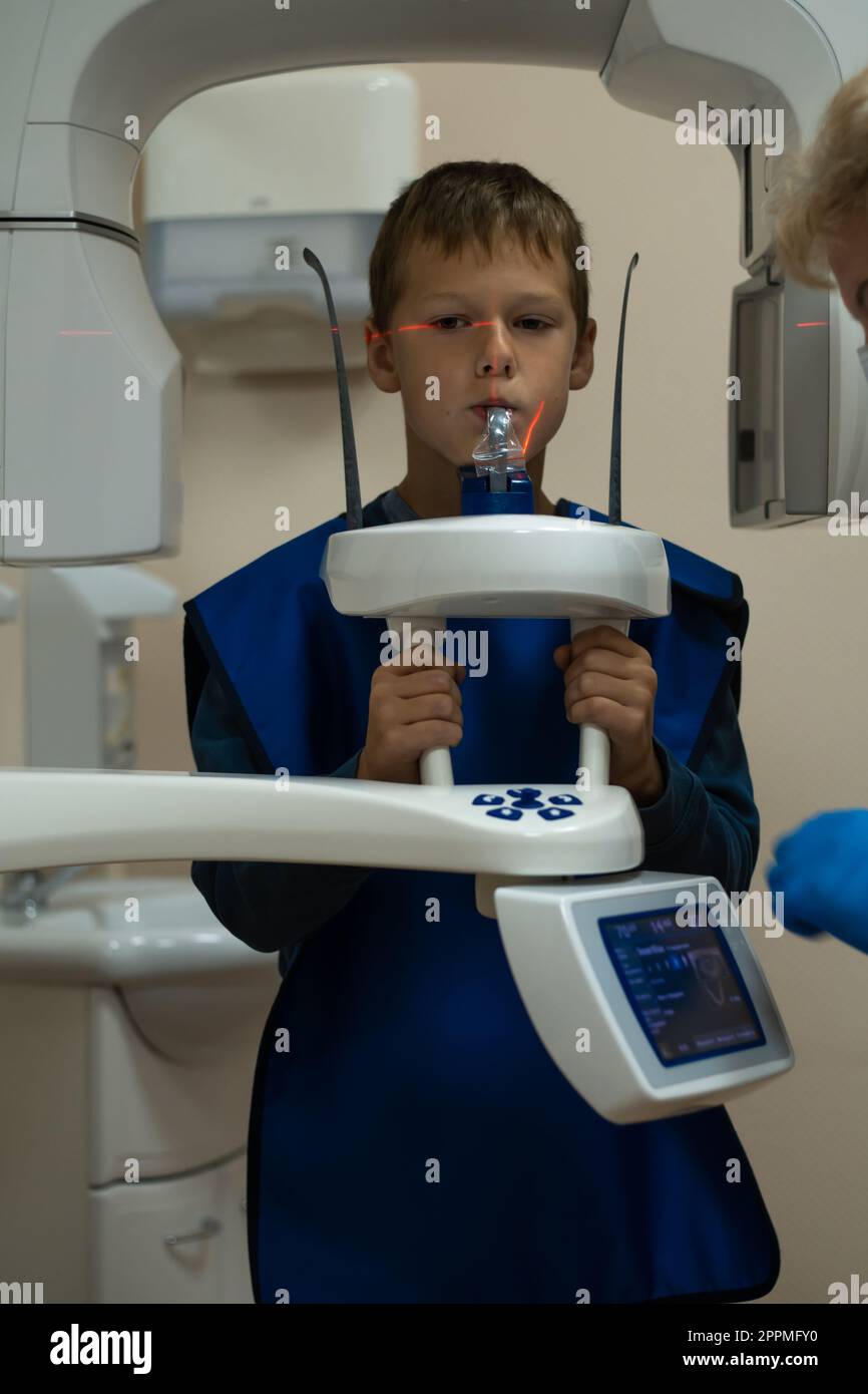 Kiefercomputertomographie, Zahnuntersuchung in der Zahnklinik. Kleiner Junge in der Röntgendiagnostik. Kreisförmige Momentaufnahme der Blende. Stockfoto