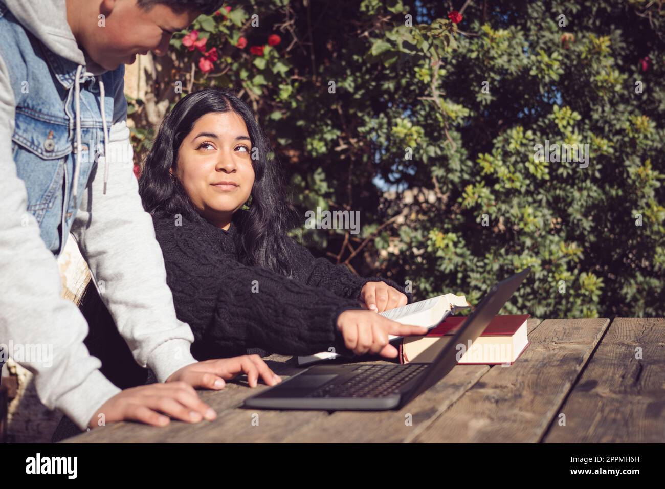 Zwei junge Männer lernen außerhalb der Schule mit Laptops Stockfoto