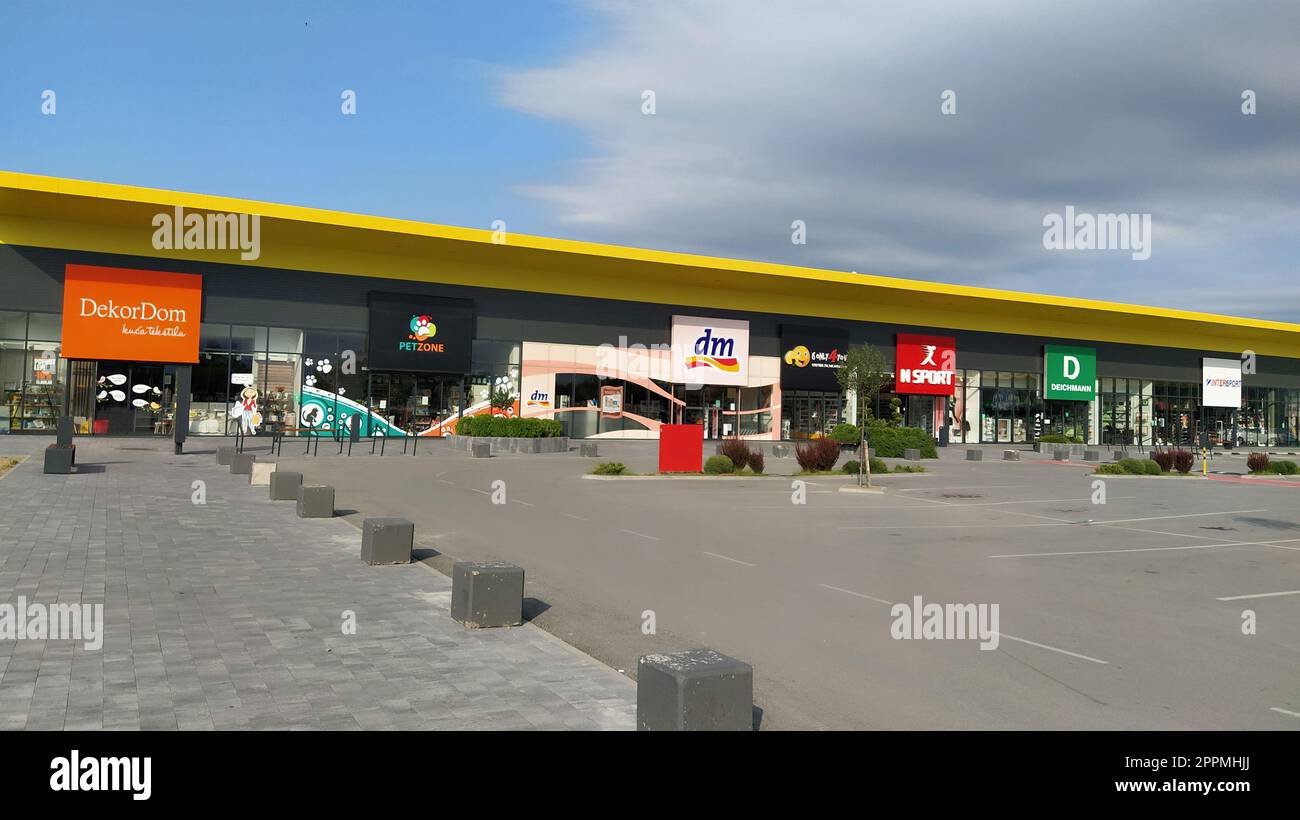 Stop Shop Shopping Center, Sremska Mitrovica, Serbien, 06. Juni 2022. Platz mit offenen Shops dm, intersport, Dekoration, ccc, lc waikiki. Menschen, Parkplätze und Bürgersteige. Sonniger Sommertag Stockfoto
