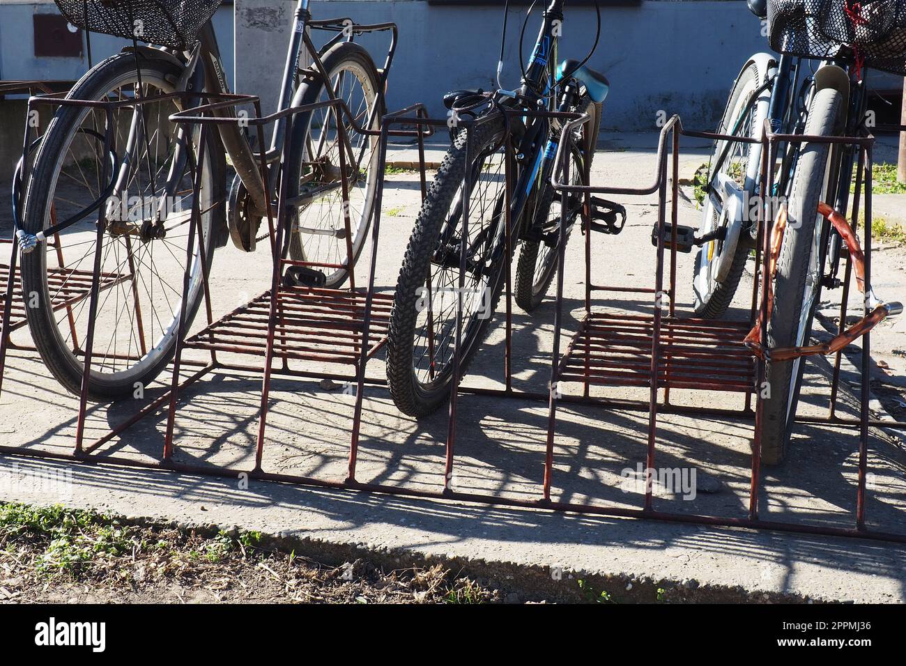 Die Fahrräder sind im Fahrradständer, an eine Metallkonstruktion gebunden. Ökologischer Stadtverkehr. Einsparungen beim Transport in Krisensituationen. Sremska Mitrovica, Serbien, 24. März 2022. Fahrräder auf der Straße. Stockfoto