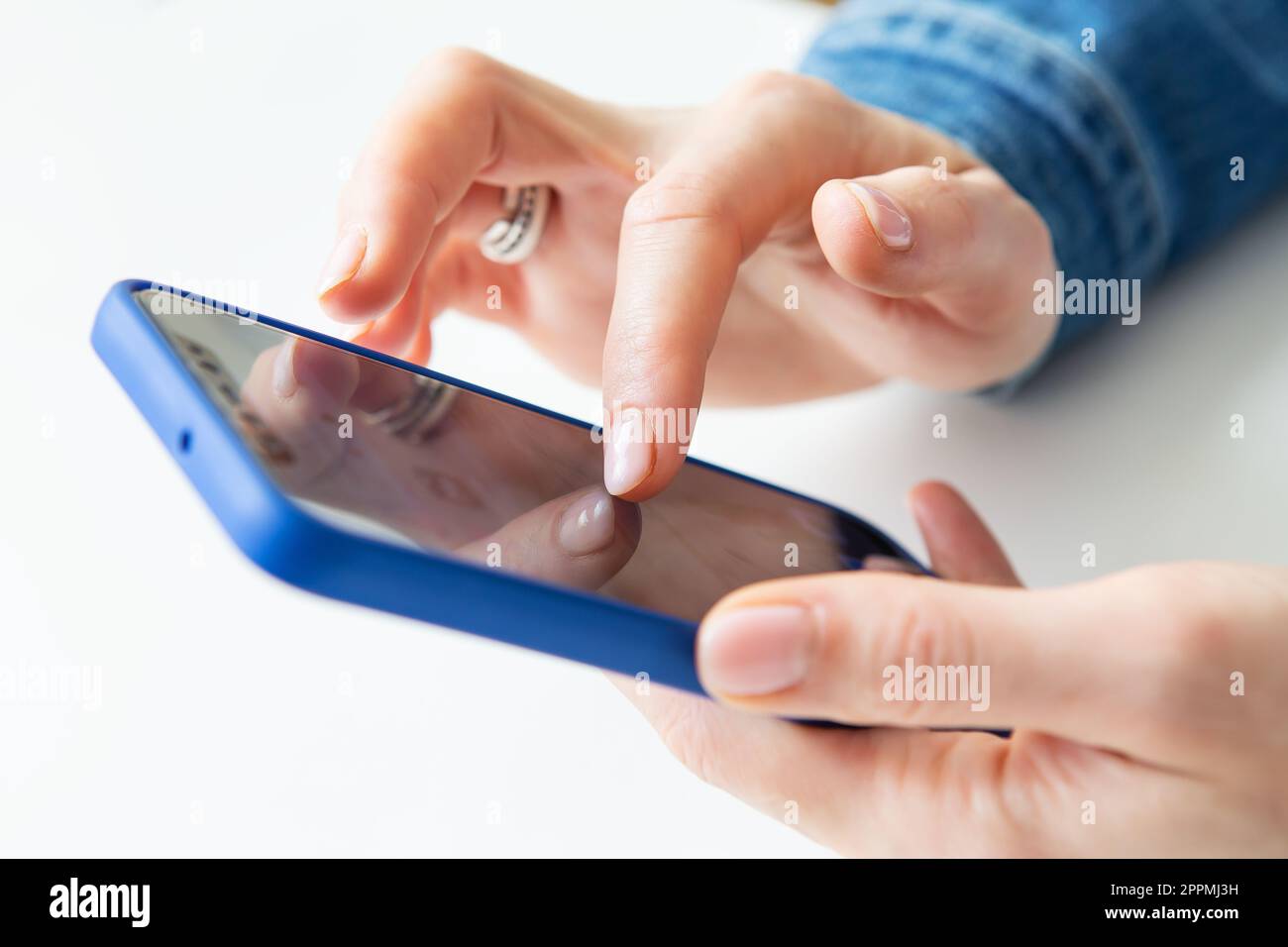 Das Mädchen hält ein Smartphone in der Hand. Das Konzept der Online-Arbeit, der freiberuflichen Arbeit, der Korrespondenz, des Chats. Nahaufnahme. Stockfoto