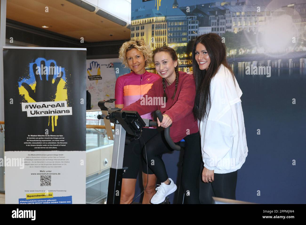 Annika Zimmermann, Svenja TheiÃŸen, Alicia Alvarez, Charity-Radfahren in der Europa-Passage, wo eine Glühbirne mit Ergometern beleuchtet ist. Das Geld geht 1:1 an ukrainische Hilfsprojekte in Zusammenarbeit mit der Organisation #WeAreAllUkra Stockfoto