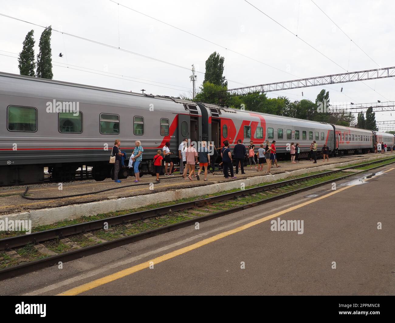 Usman, Region Lipetsk, Russland, 7. August 2021. Bahnhof der südöstlichen Eisenbahn. Der Bahnsteig mit den Leuten, die aus dem Zug gestiegen sind. Passagierzug der Russian Railways. Geländer und Schläfer. Zwischenstopp Stockfoto
