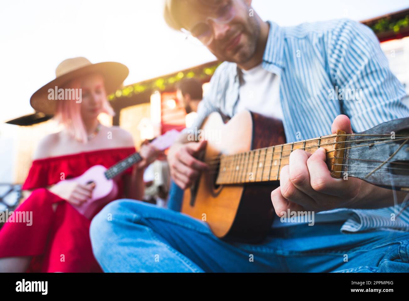 Freunde machen ein Picknick und spielen mit der Gitarre Stockfoto