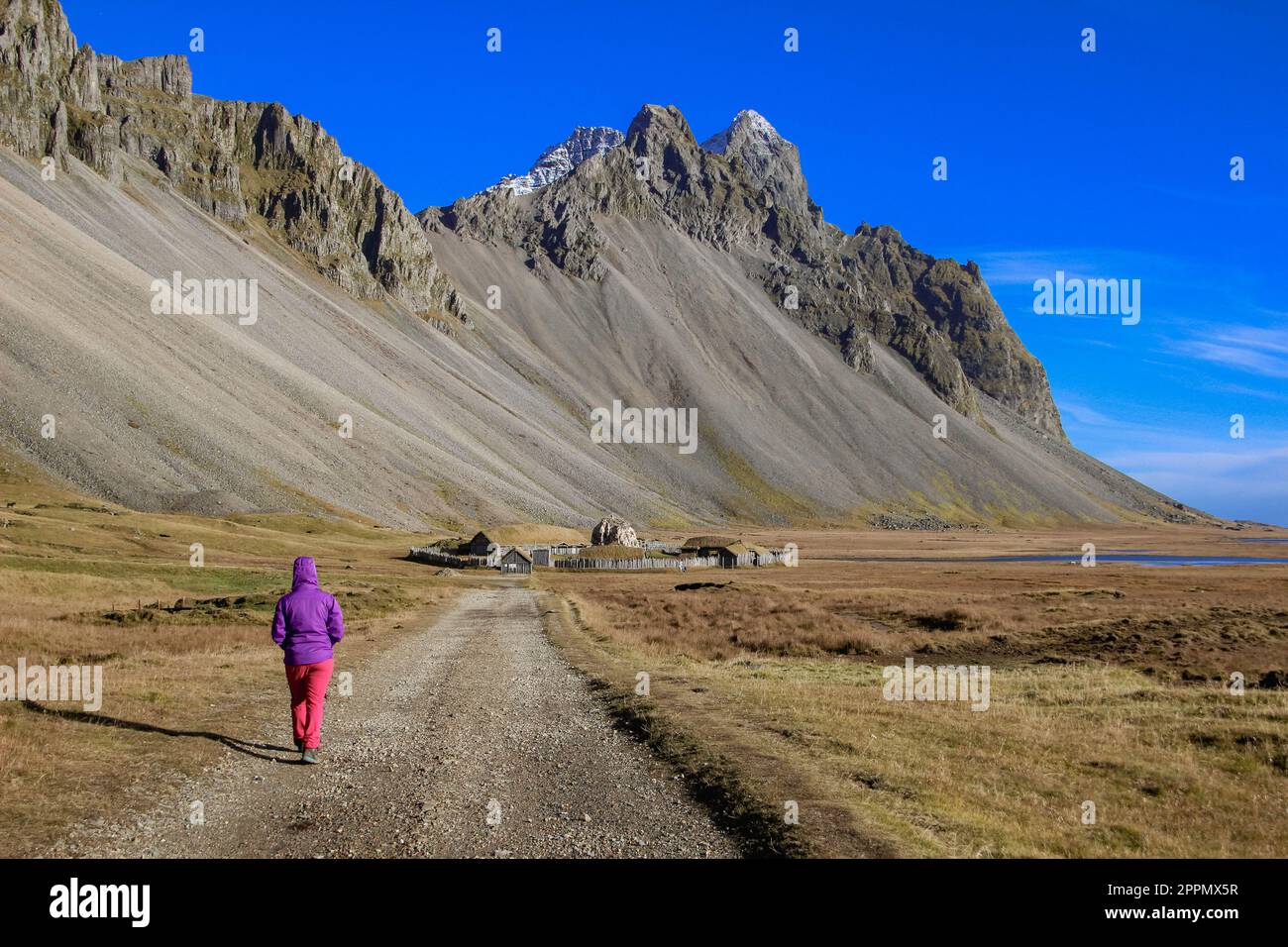 Frau, die in Richtung wikingerdorf in Stokksnes unter dem Vestrahorn-Berg in Island geht Stockfoto