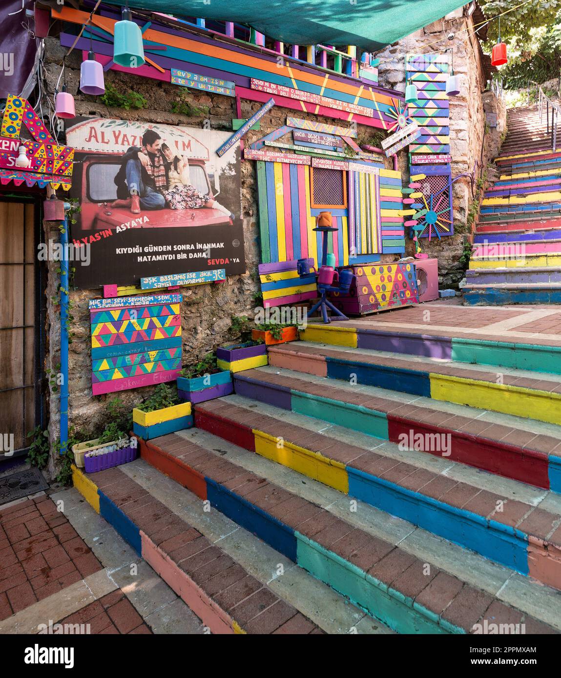 Tagsüber gibt es ein Café aus Stein mit bunten Paneelen, farbenfrohen Treppen und Balat District, Istanbul, Türkei Stockfoto