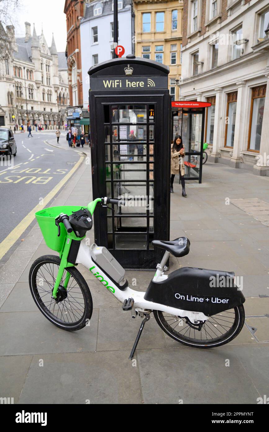 London, England, Großbritannien. Limettenverleih vor einer WiFi-fähigen alten Telefonzelle im Strand Stockfoto