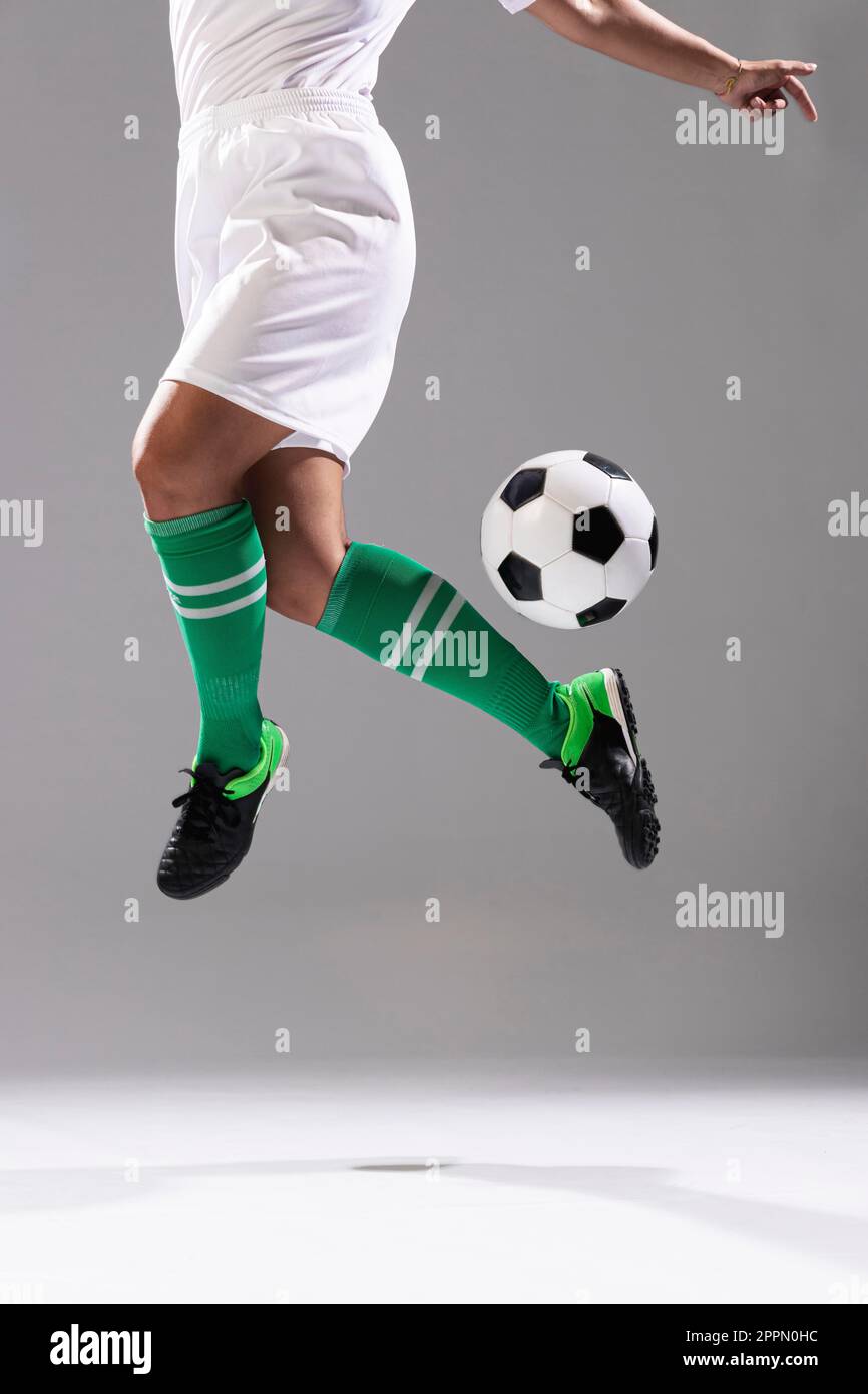 Erwachsene Frau macht Tricks mit Fußball Stockfoto