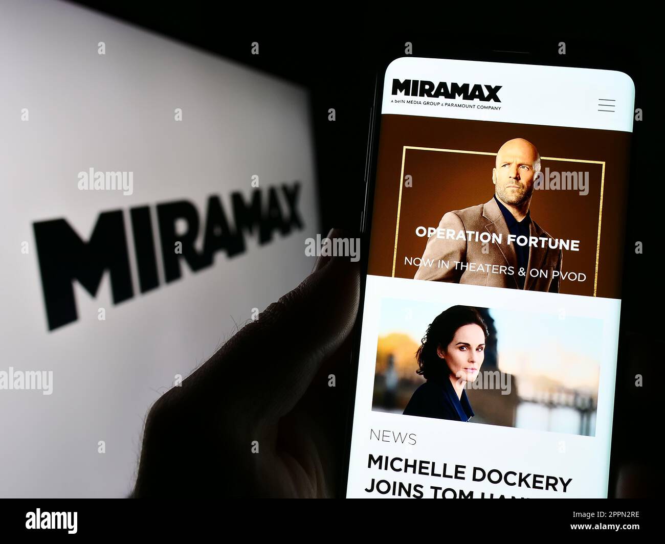 Person, die ein Mobiltelefon mit einer Webseite des US-Fernsehproduktionsunternehmens Miramax LLC auf dem Bildschirm mit Logo hält. Konzentrieren Sie sich auf die Mitte des Telefondisplays. Stockfoto