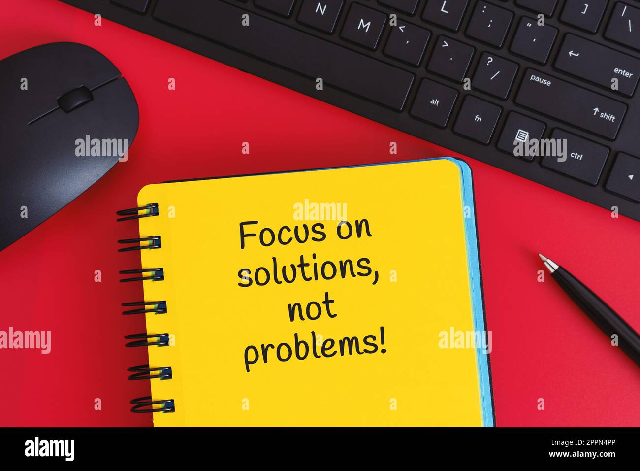 „Yellow Notebook with Writed Life Lesson“ – ein gelbes Notizbuch mit einer schriftlichen Lektion auf rotem Hintergrund. Stockfoto