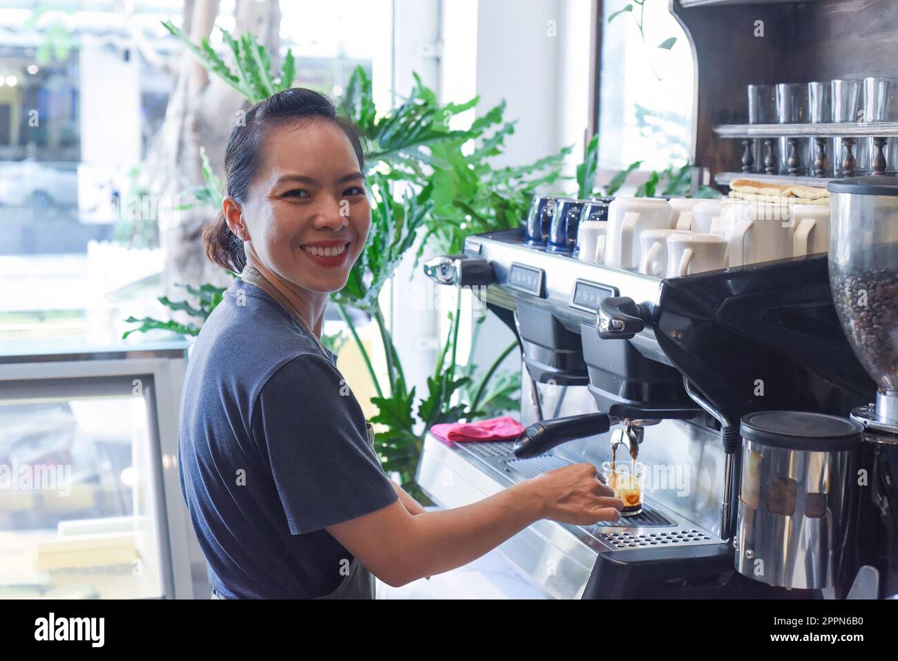 Vietnamesischer Barista, der Espresso aus nächster Nähe mit der Kaffeemaschine zubereitet Stockfoto