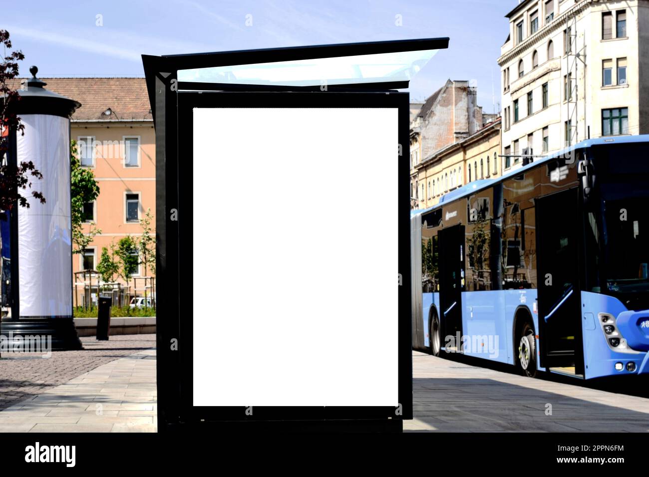Leere weiße Anzeige und Werbetafel. Modellbasis. Leerer Posterhintergrund. Weicher urbaner grüner Hintergrund. Anzeigenbereich im vertikalen Format. Stockfoto