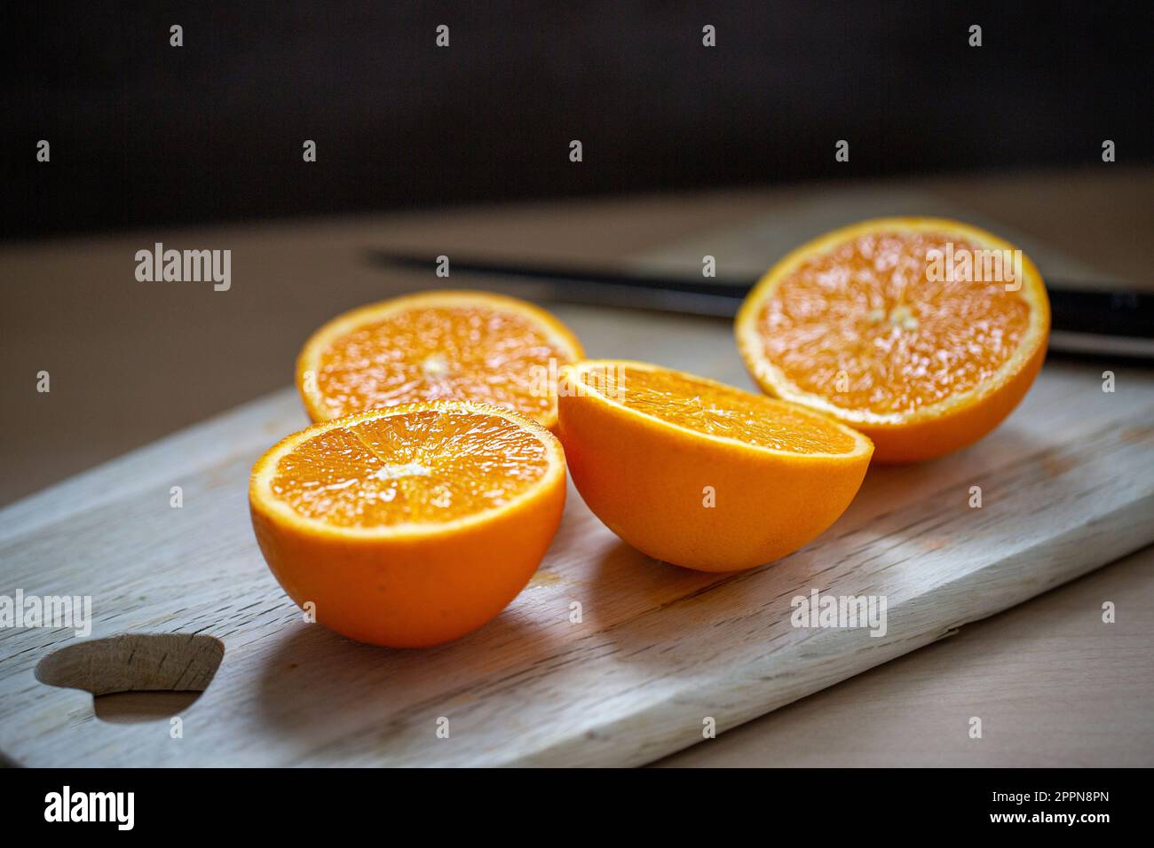 Leckere saftige Orangen liegen aufgeschnitten auf einem Holzbrett Stockfoto