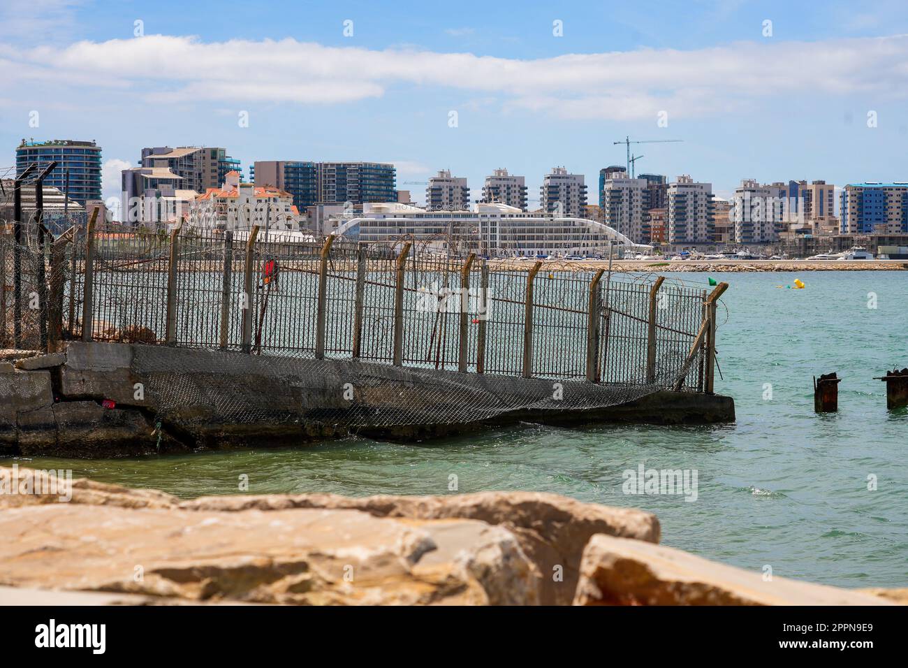 Internationale Grenze zwischen Spanien und Gibraltar, am Rande des Schengen-Raums - Zaun mit Stacheldraht im Mittelmeer Stockfoto