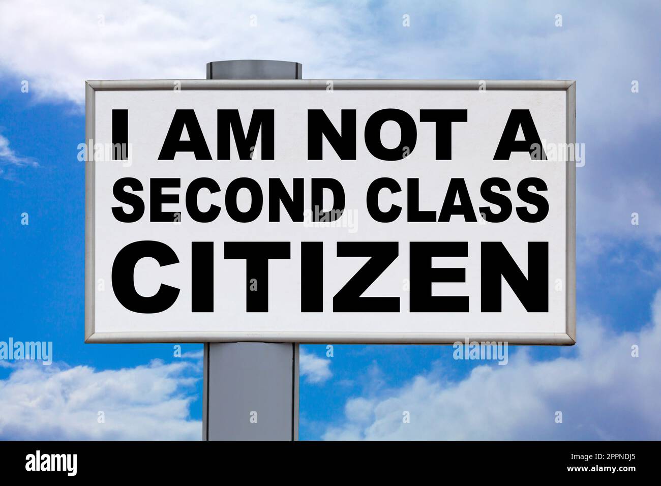 Nahaufnahme auf einer weißen Plakatwand vor einem blauen Himmel mit der Meldung „Ich bin kein Bürger zweiter Klasse“ in der Mitte in Schwarz. Stockfoto