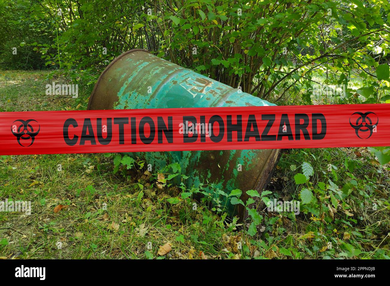 Verlassenes Fass im Wald mit einem Polizeivideo, auf dem "Vorsicht Biohazard" steht. Stockfoto