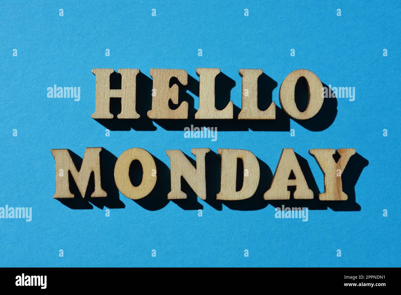 Hallo Montag, Wörter in hölzernen Buchstaben isoliert auf hellblauem Hintergrund Stockfoto
