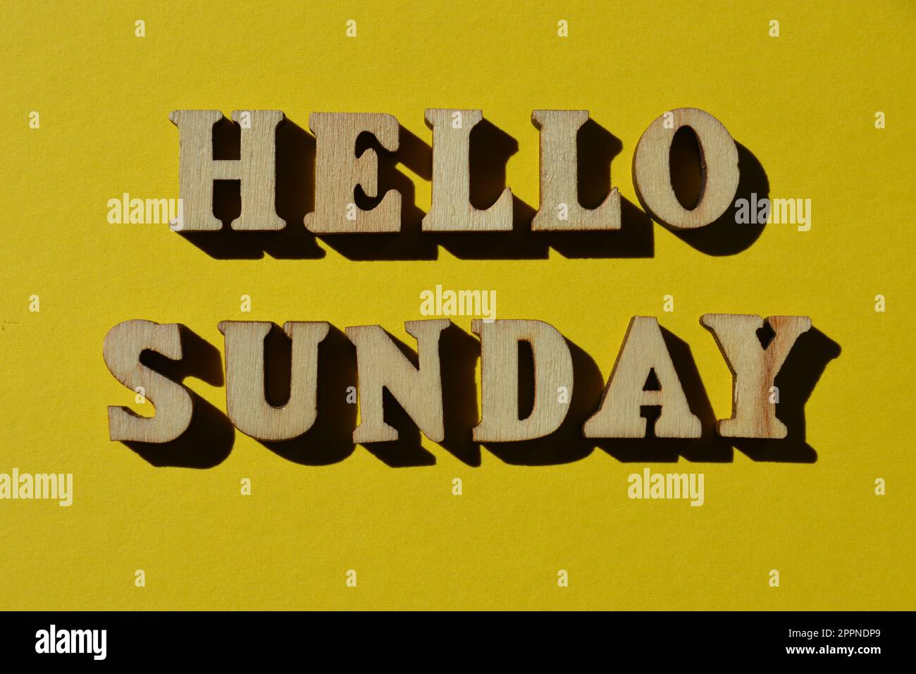 Hallo Sonntag, Wörter in hölzernen Buchstaben isoliert auf gelbem Hintergrund Stockfoto