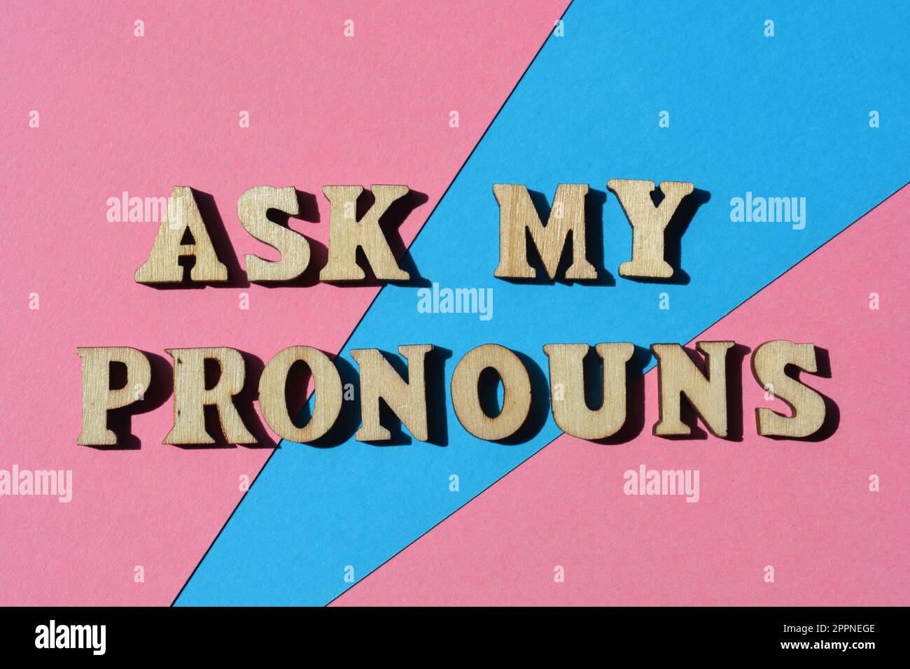 Frag meine Pronomen, Wörter in hölzernen Buchstaben isolierter rosa-blauer Hintergrund Stockfoto