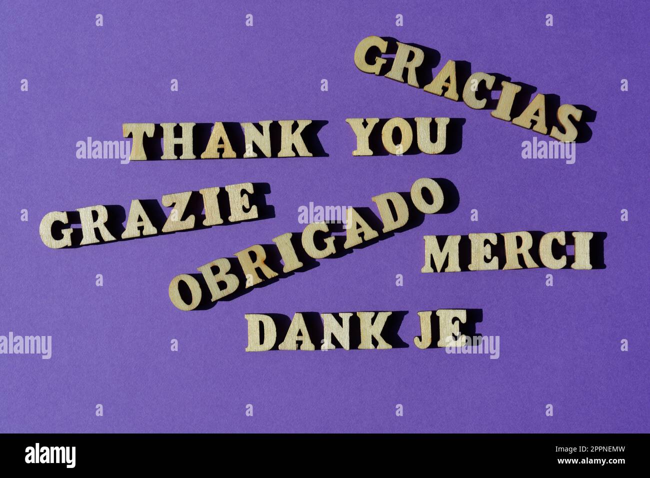 Danke, Wort in Englisch und verschiedenen europäischen Sprachen, isoliert auf lila Hintergrund Stockfoto