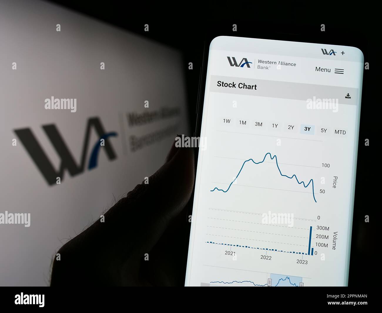 Person, die ein Mobiltelefon mit einer Website der US-amerikanischen Western Alliance Bancorporation auf dem Bildschirm vor dem Logo hält. Konzentrieren Sie sich auf die Mitte des Telefondisplays. Stockfoto
